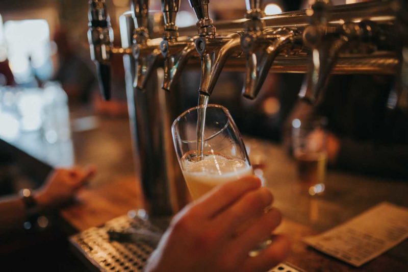 Beer being poured from a draught tap into a glass