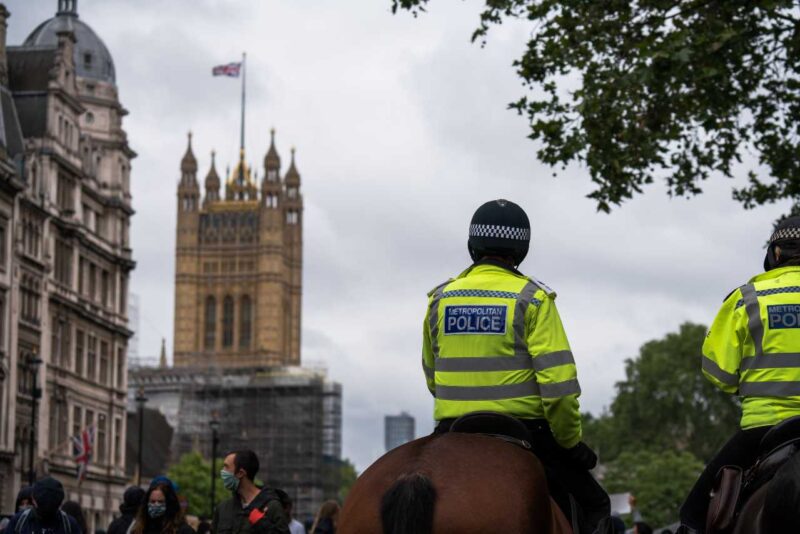 Two police officers on horseback with Parliament in the background