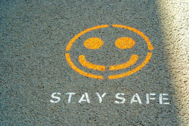 Smiley face painted on a pavement with the words Stay Safe