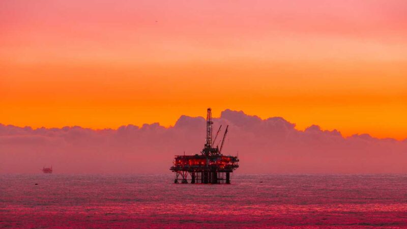 Oil rig in the sea against a sunset skyline