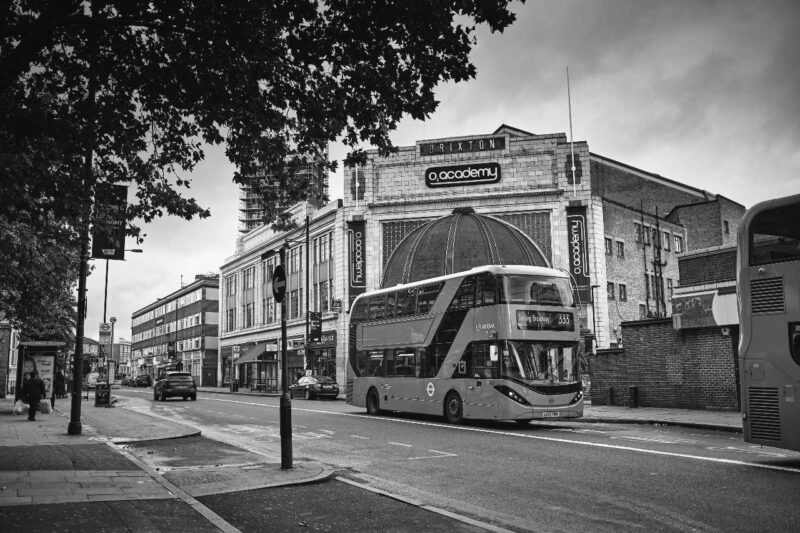 Black and white image of the O2 Academy Brixton with a London bus in front of it