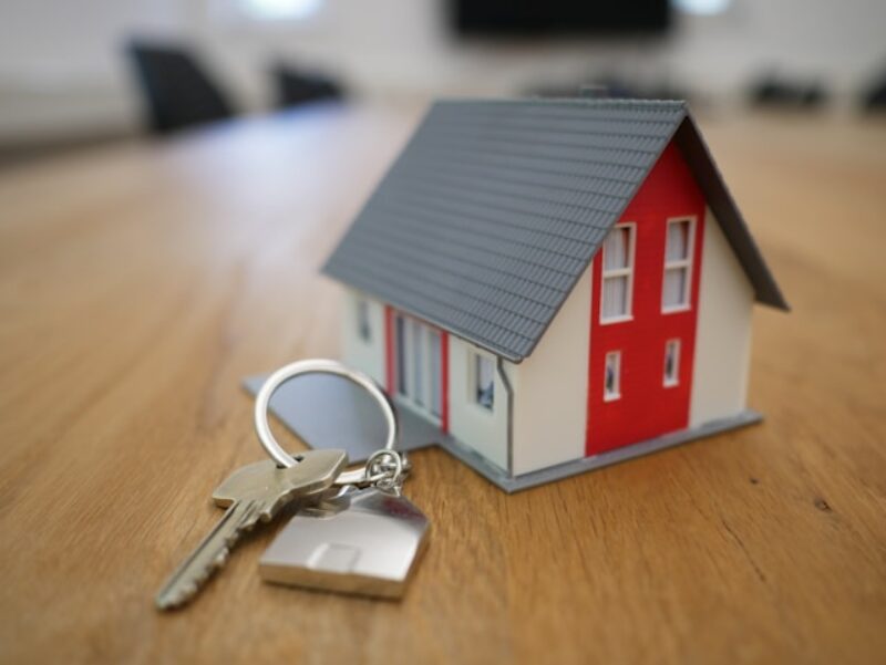 A miniature house next to keys