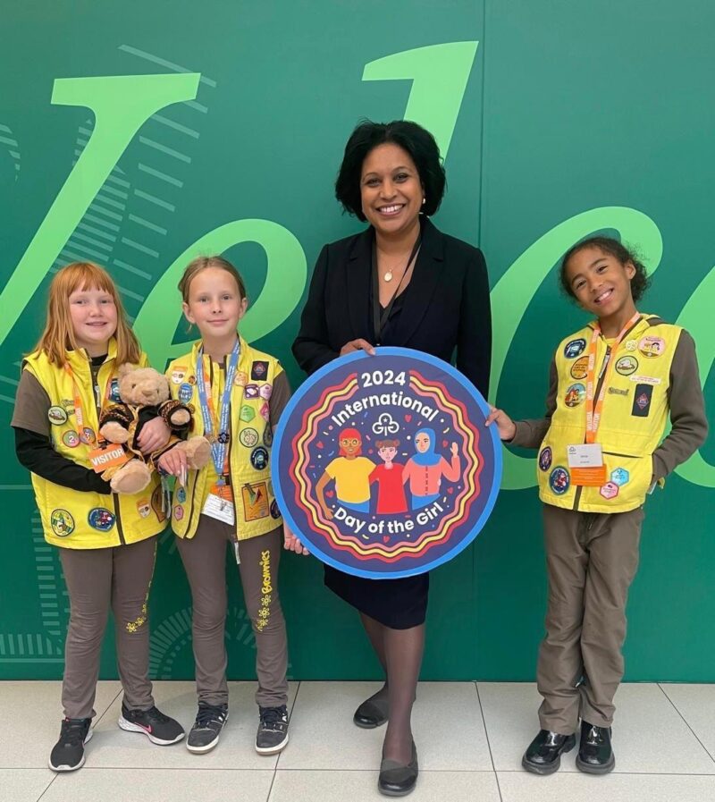 Janet Daby MP alongside 3 girls from the Brownies. Janet is holding a sign saying " 2024 International Day of the Girl"