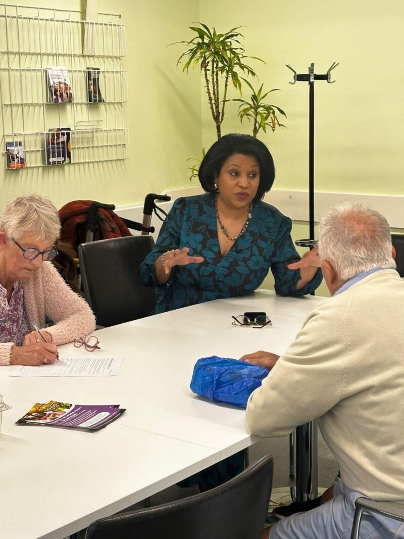 Janet sits in between two people explaining the Government